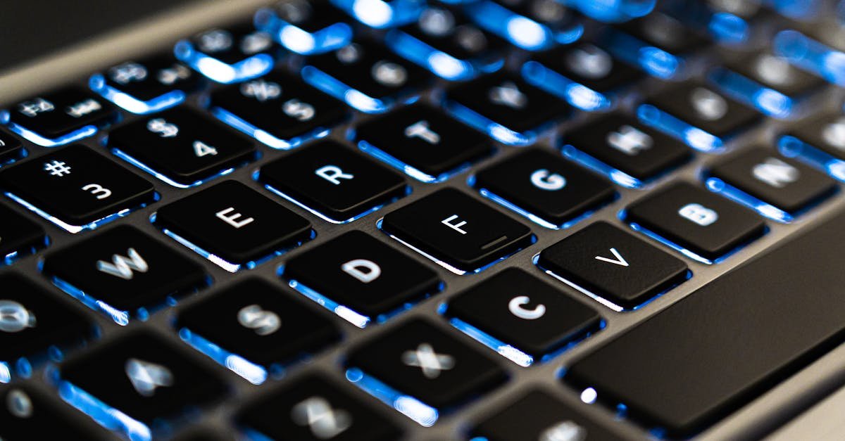 Detailed view of a backlit laptop keyboard keys with blue LED lighting for tech concepts.